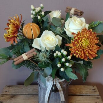 Metal churn of Christmas flowers in bronze and cream.